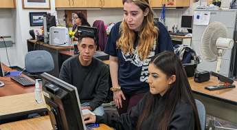 Student at a computer receiving enrollment help from an LAMC representative