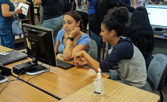 An LAMC representative helping a student enroll at a computer