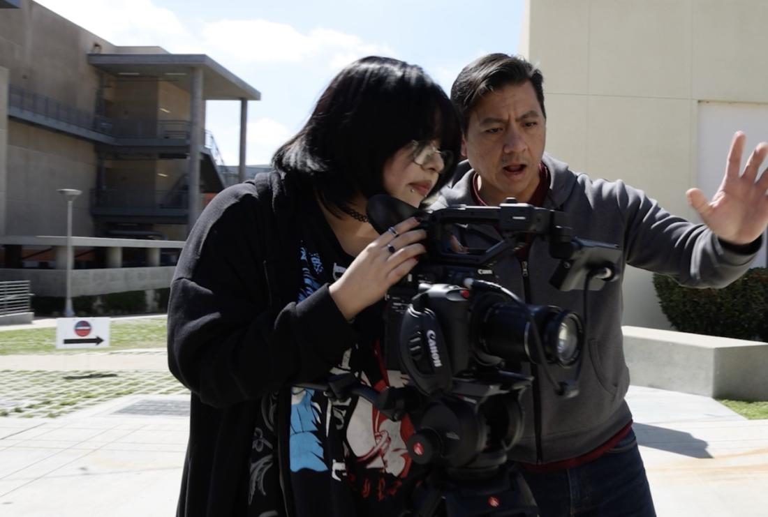 student and faculty with video camera