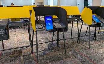 Voting booths with tablets that read VOTE